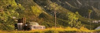 an old truck sits in the middle of a mountain