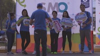 a group of people standing in front of a banner with the word gmo