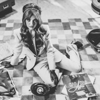 a woman in a suit sitting on the floor