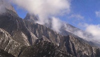 a mountain range with clouds in the sky