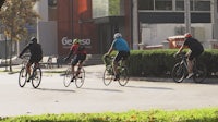 a group of people riding bicycles down a street